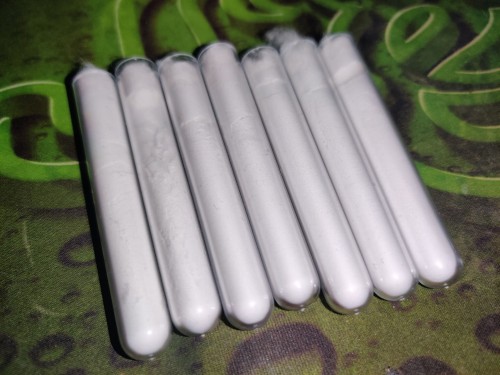 Seven plastic test tubes filled with pure 100% white talc powder for ant escape barrier.