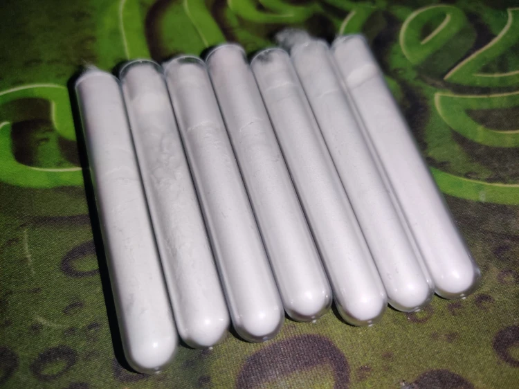 Sept tubes à essai en plastique remplis de talc pur 100% blanc comme barrière anti-évasion.