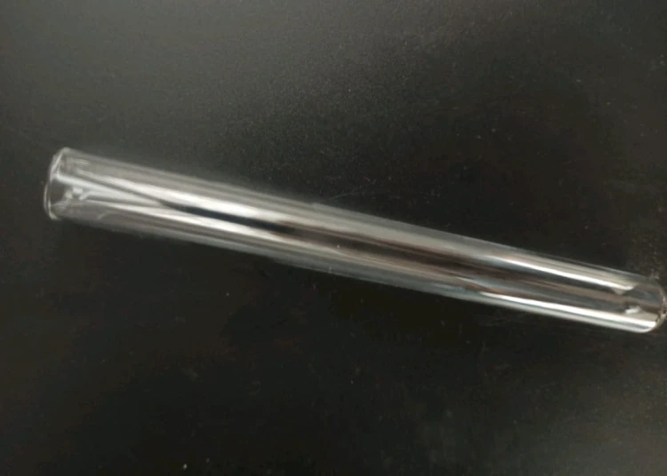 Tube à essai en verre transparent 16x160mm pour l'élevage de fourmis sur fond noir.